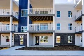 Cypress Point in Washington, Indiana: the front of the three storey apartment building, with stacked balconies above a dark brick base and a navy accent bay.