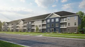 Published exterior rendering of Bierhaus Flats showing a long three-story apartment building with gray and blue siding, white balconies and a street in front.
